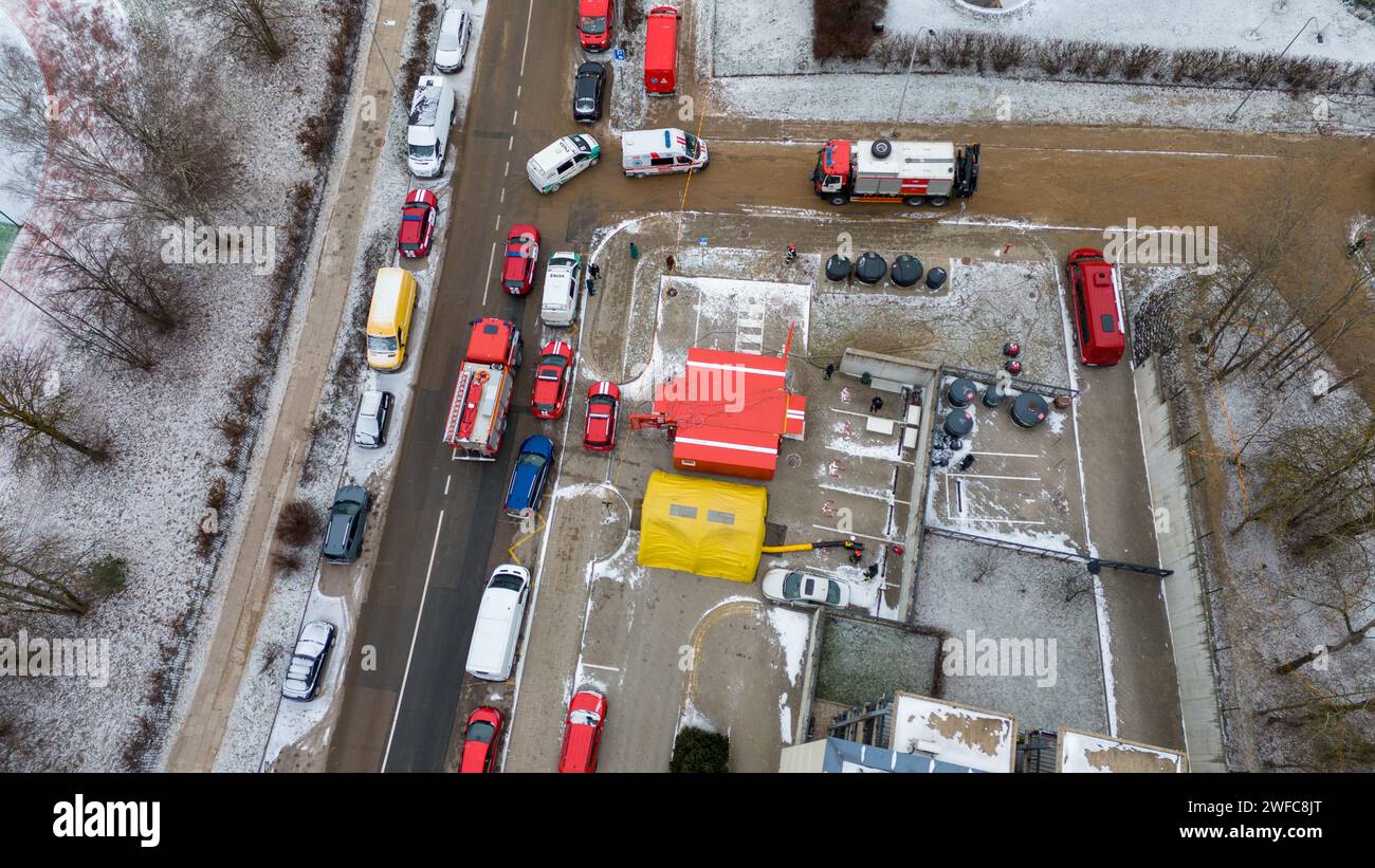 Drohnenfotografie des Notdienst-Kontrollpunktes in der Nähe eines verbrannten Gebäudes in einer Stadt während des bewölkten Wintertages Stockfoto