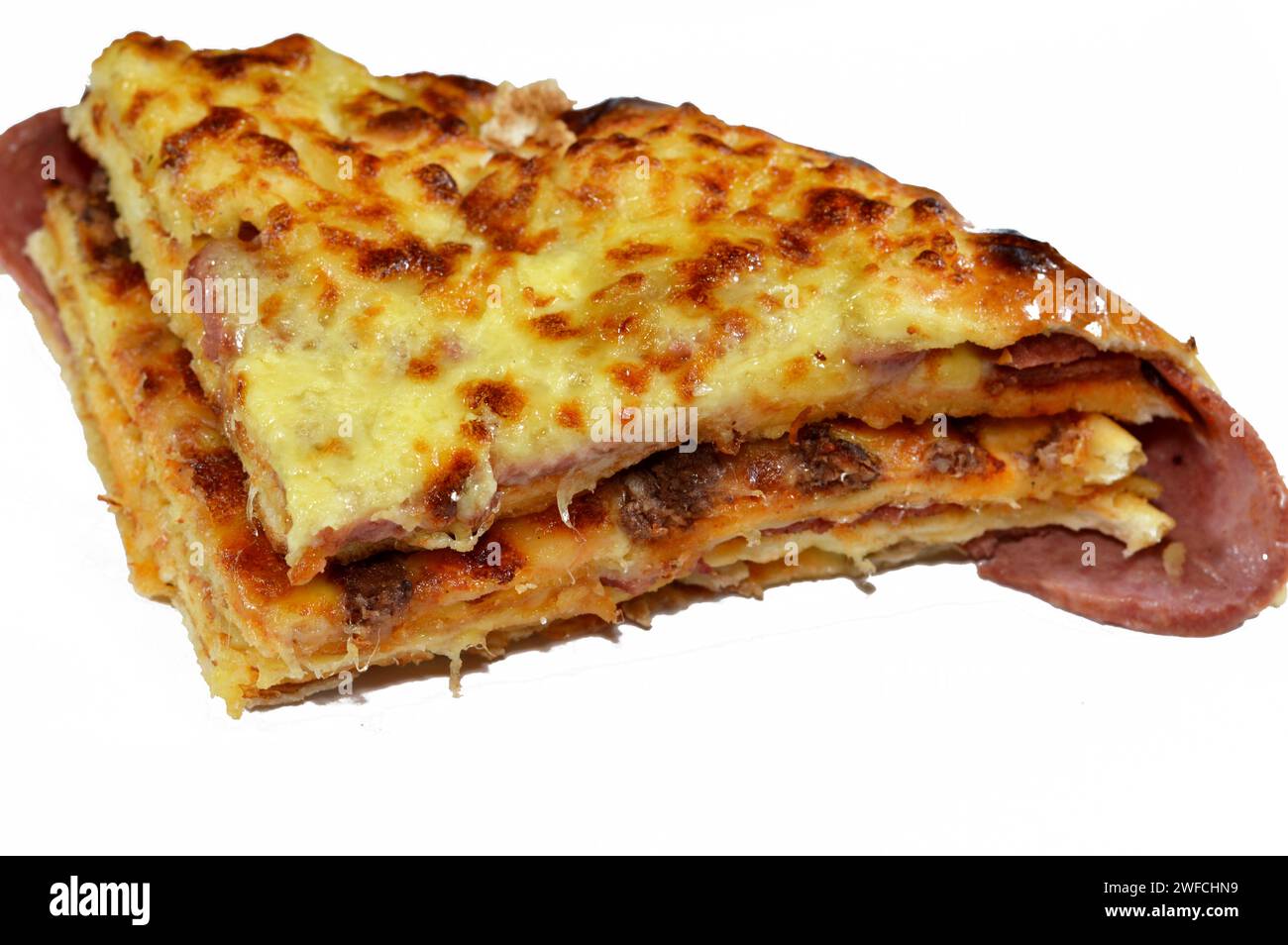 Mehrschichtiger gebackener Pizzakuchen, bestehend aus Lagen Salami, Grillhähnchen, Käsemischung, Rindfleisch, Wurst, Mozzarella-Käse, im Ofen gebacken, Italia Stockfoto