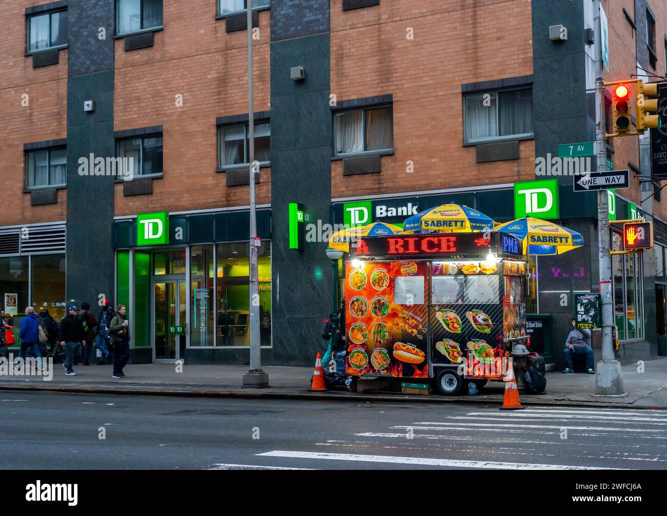 Die Farben eines Halal Food Carts stehen im Kontrast zur TD Bank-Ladenfront in Chelsea in New York am Donnerstag, den 25. Januar 2024. (© Richard B. Levine) Stockfoto