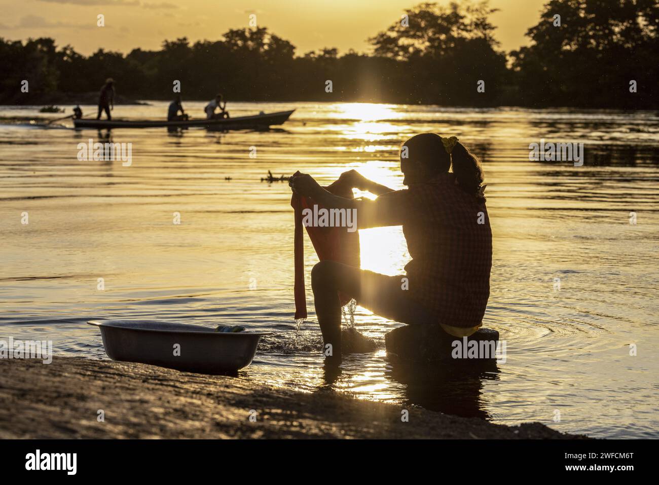 Silhouette einer Frau, die im Wasser des Flusses São Francisco Kleidung wäscht. - Stockfoto