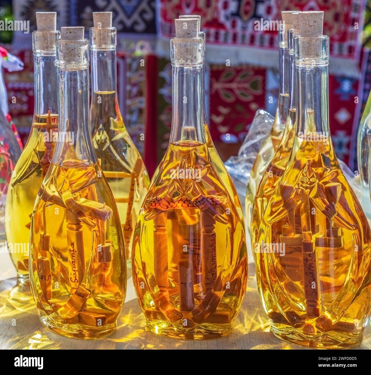 SAPANTA, MARAMURES, RUMÄNIEN - 18. SEPTEMBER 2020: Traditionelles rumänisches Getränk (Tuica) in Flaschen mit Holzkreuzen im Inneren. Stockfoto