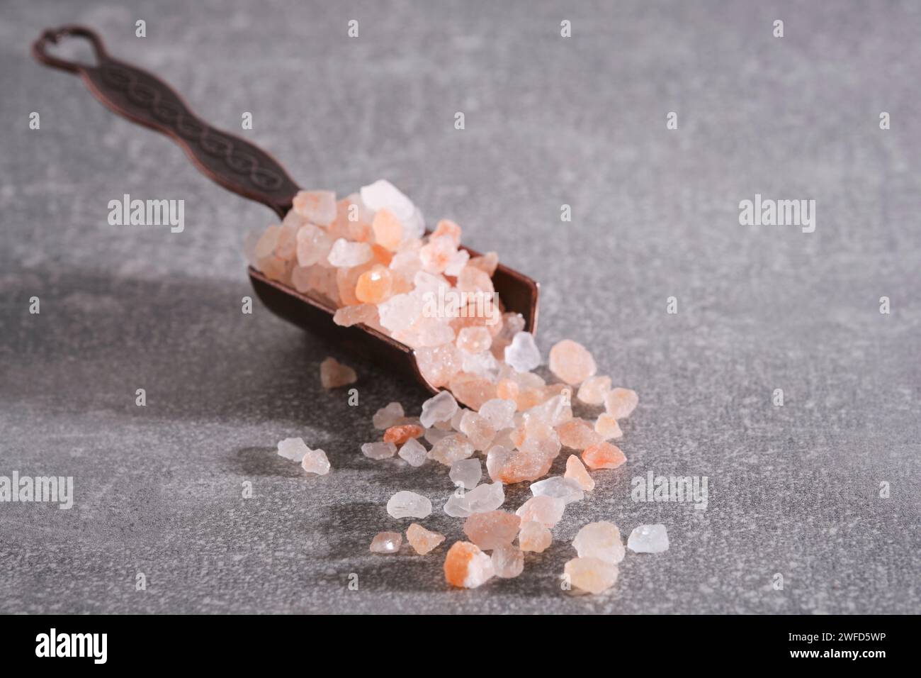 Der Gewürzlöffel ist mit rosa Himalaya-Salz gefüllt Stockfoto