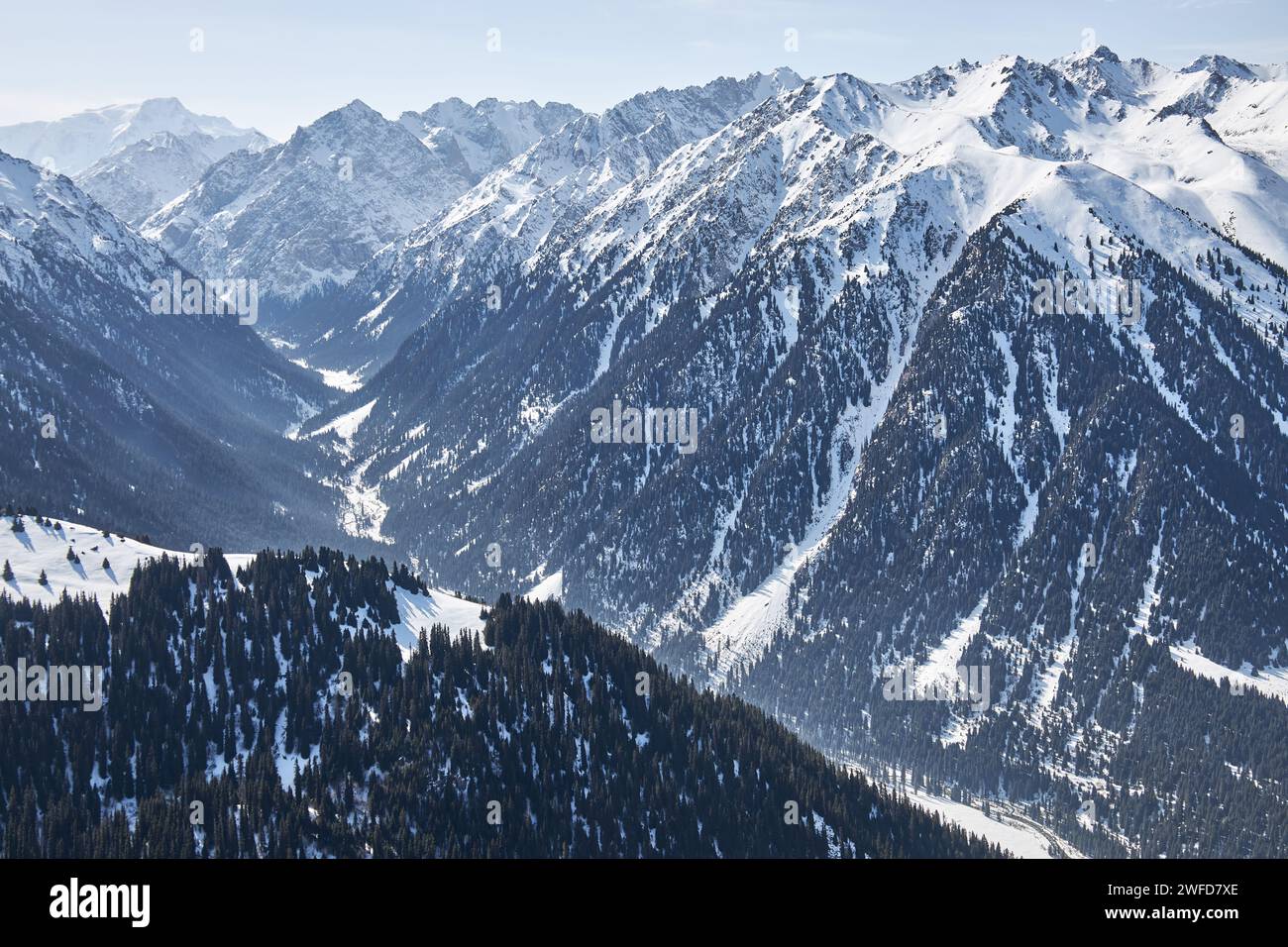 Panoramablick von der Spitze der Hanglage auf schneebedeckte hohe Berge. Karakol Gorge, Skigebiet in Kirgisistan. Winterlandschaft, Bergkette Stockfoto