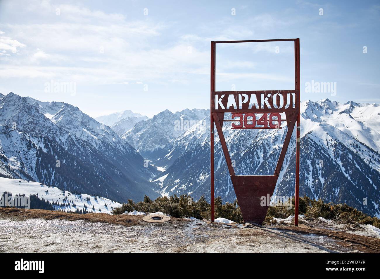 Skigebiet Karakol. Schild auf der Spitze des Berges 3040 Meter über dem Meeresspiegel. Panoramablick auf die Winterberge in Kirgisistan. Schneebedeckte Gipfel, nat Stockfoto