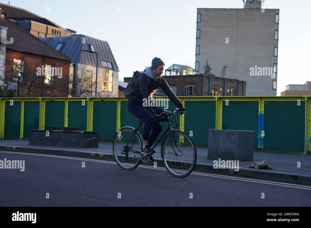 Ein Radfahrer pendelt in Hackney in der frühen Wintersonne und überquert den Regent's Canal. Stockfoto