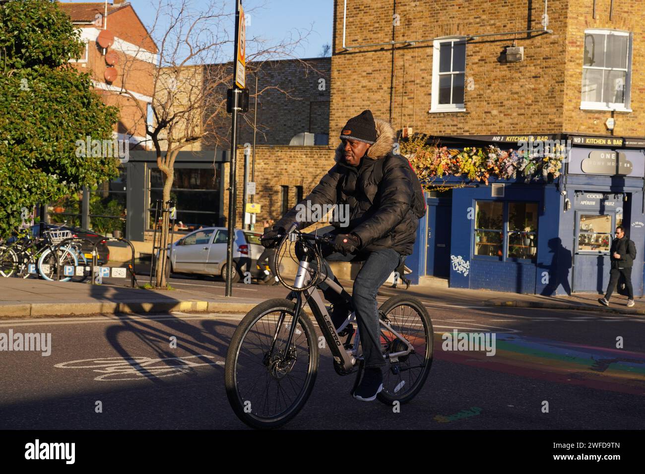 Ein Radfahrer pendelt in Hackney, East London, in der frühen Morgensonne des Winters am 26. Januar 2024, London, Großbritannien. Stockfoto