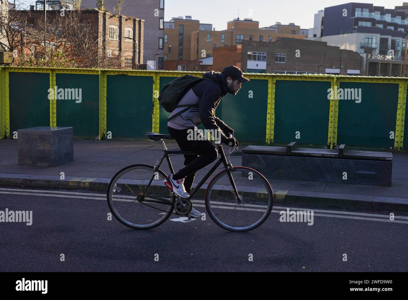 Ein Radfahrer pendelt in Hackney, East London, in der frühen Morgensonne des Winters am 26. Januar 2024, London, Großbritannien. Stockfoto