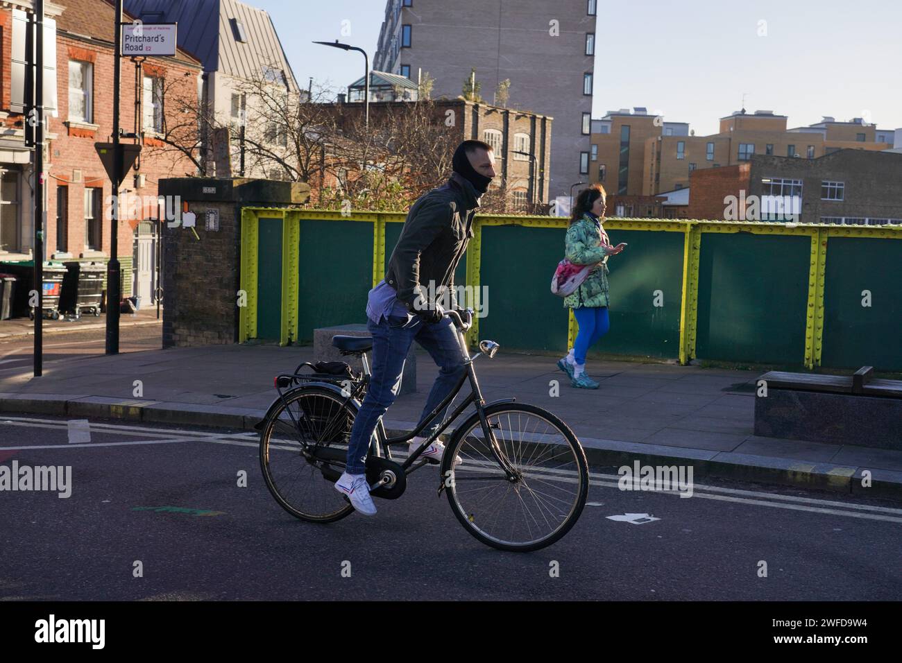 Ein Radfahrer pendelt in Hackney, East London, in der frühen Morgensonne des Winters am 26. Januar 2024, London, Großbritannien. Stockfoto