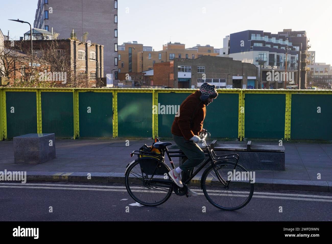 Ein Radfahrer pendelt in Hackney, East London, in der frühen Morgensonne des Winters am 26. Januar 2024, London, Großbritannien. Stockfoto