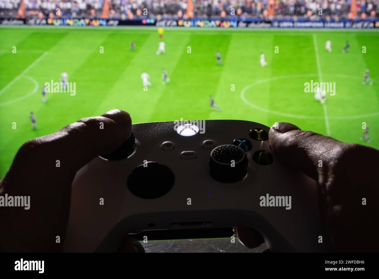 Dnipro, Ukraine, 28. september 2023: Mann spielt EA FC 24 mit Xbox-Controller auf dem Fernsehbildschirm, Stockfoto