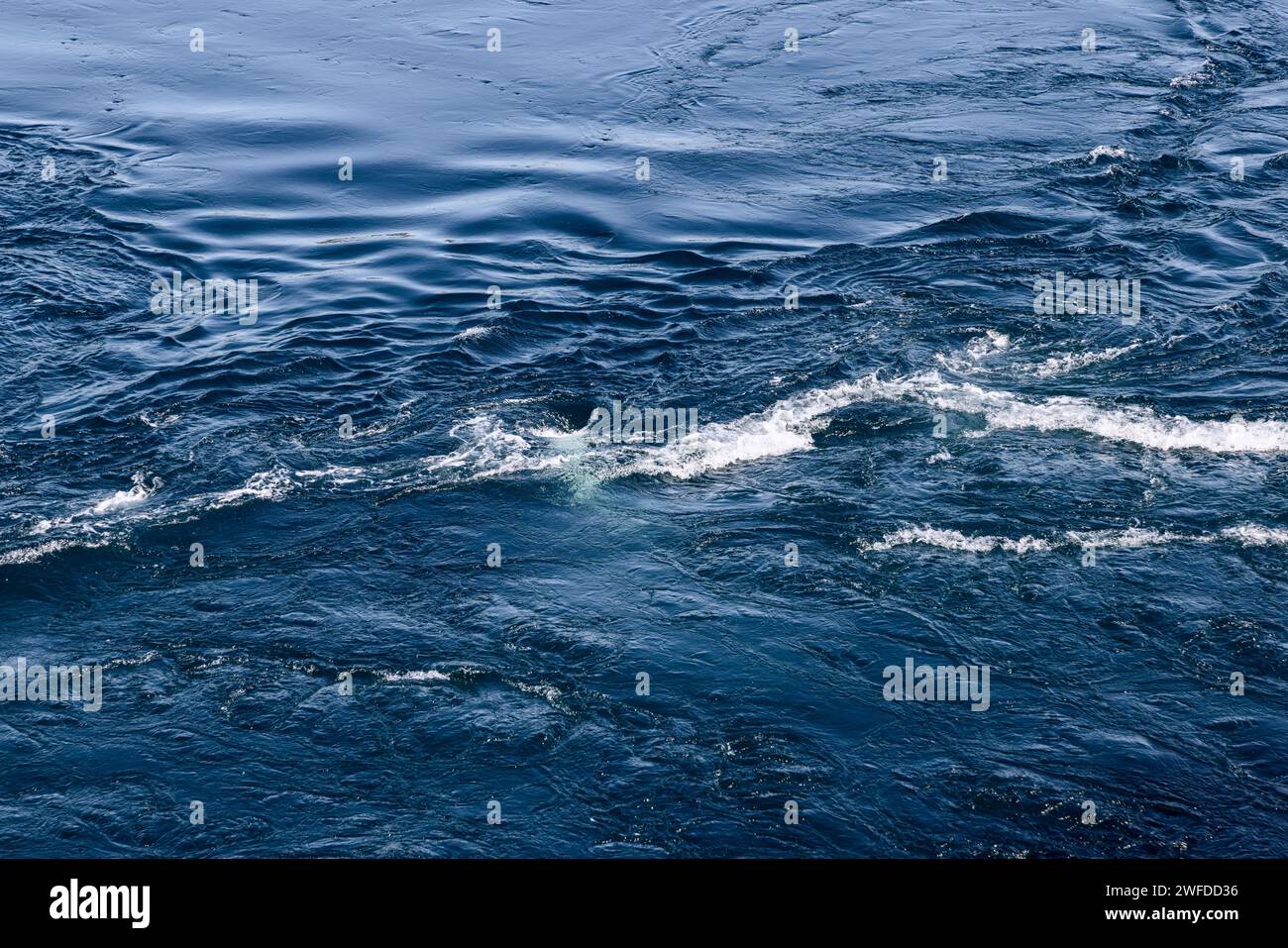 Die gewaltigen Gezeitenströmungen von Saltstraumen ziehen sich durch das Wasser und schaffen eine atemberaubende, strukturierte Oberfläche aus faszinierenden Wirbeln und Wirbeln Stockfoto