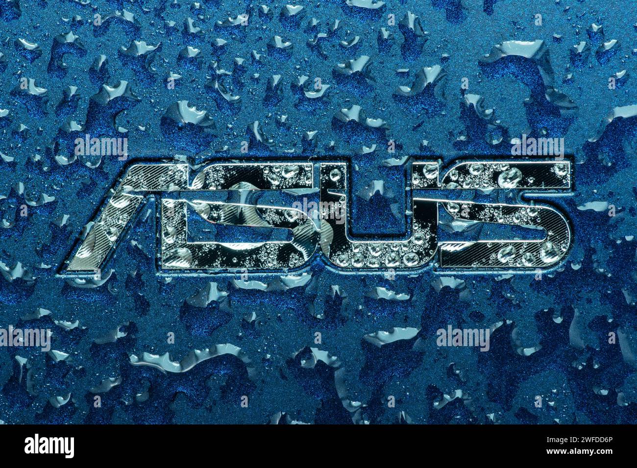 UKRAINE, DNEPR - 02. OKT 2023: ASUS Firmenlogo auf Laptop mit Wassertropfen. Stockfoto