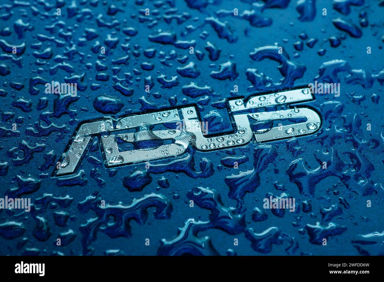 UKRAINE, DNEPR - 02. OKT 2023: ASUS Firmenlogo auf Laptop mit Wassertropfen. Stockfoto