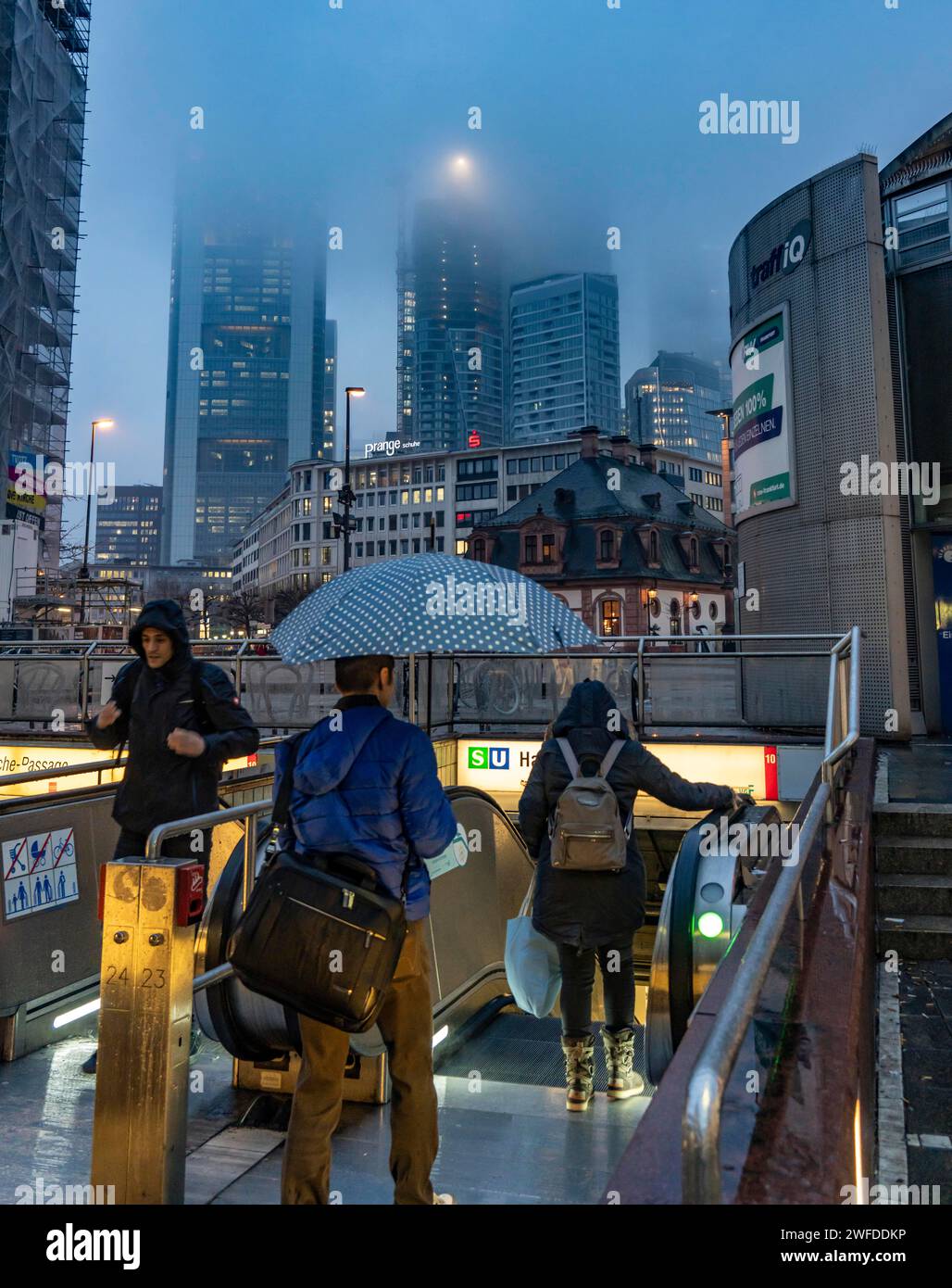 Regnerisches Wetter, eiskalter Regen, Eingang zur U-Bahn-Station Hauptwache, Hochhaus-Skyline in Wolken, Passanten, die durch das feuchte, eiskalte Wetter eilen, F Stockfoto