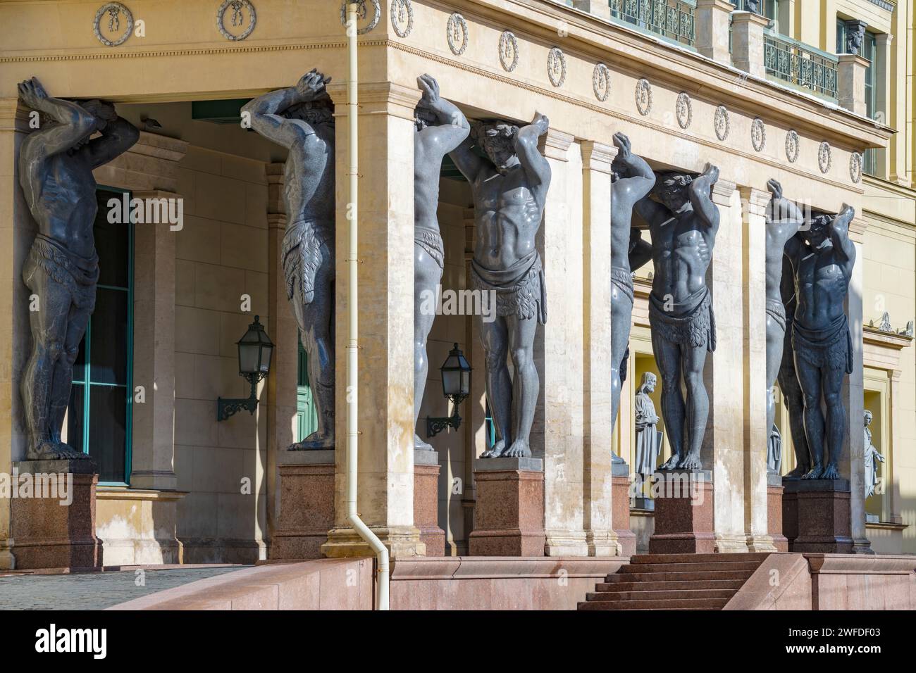 SANKT PETERSBURG, RUSSLAND - 2. APRIL 2023: Portikus mit Atlanten des Neuen Eremitage-Gebäudes an einem sonnigen Tag aus nächster Nähe Stockfoto
