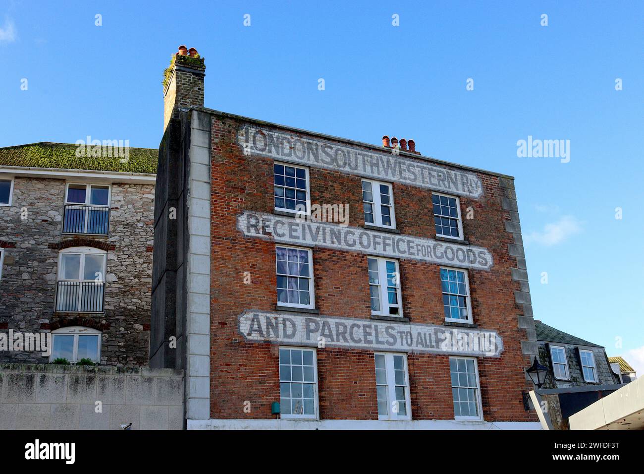 Das ehemalige Büro der London & South Western Railway an der Barbican Waterfront, Plymouth, Devon, mit gemalter viktorianischer Kalligraphie auf der Backsteinfassade. Stockfoto