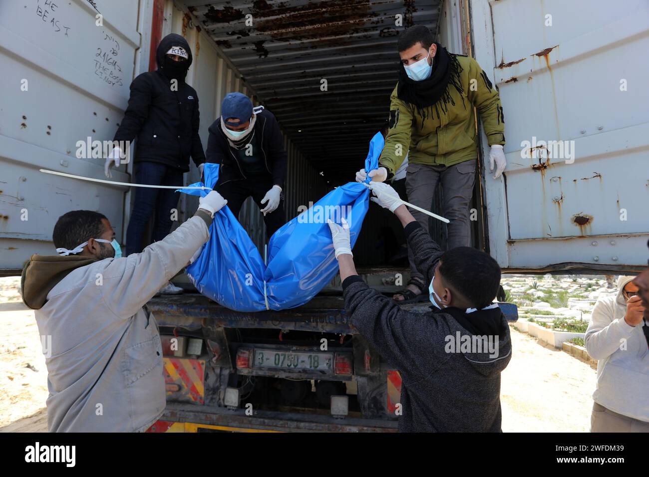 Rafah, Gaza. 30. Januar 2024. Mitarbeiter des palästinensischen Gesundheitsministeriums in Gaza bereiten sich darauf vor, die Leichen nicht identifizierter Palästinenser zu begraben, deren Todesdatum nicht bekannt ist, nachdem sie von Israel am selben Tag durch den Kerem-Schalom-Grenzübergang zurückgebracht wurden, in einem Massengrab östlich von Rafah im südlichen Gazastreifen. am Dienstag, 30. Januar 2024. Palästinenser beerdigten Dutzende Leichen in einem Massengrab im Süden von Rafah, nachdem Beamte aus Gaza sagten, Israel habe die Überreste von Menschen zurückgegeben, die es aus dem Territorium exhumiert hatte. Foto: Ismael Mohamad/UPI. Quelle: UPI/Alamy Live News Stockfoto