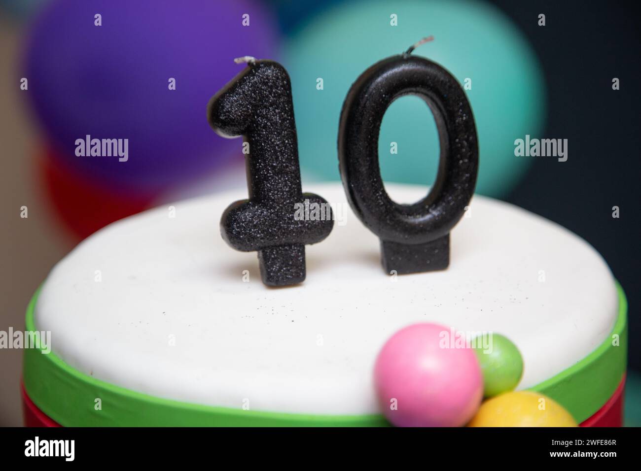 Ein lebendiger Kuchen mit festlichen Ballons und einer Kerze Nummer 10 Stockfoto