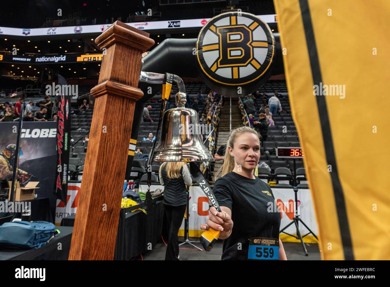 Frau läutet am Ziel der 8. Jährlichen BFit Challenge, die von der Boston Bruins Foundation organisiert wird. Stockfoto