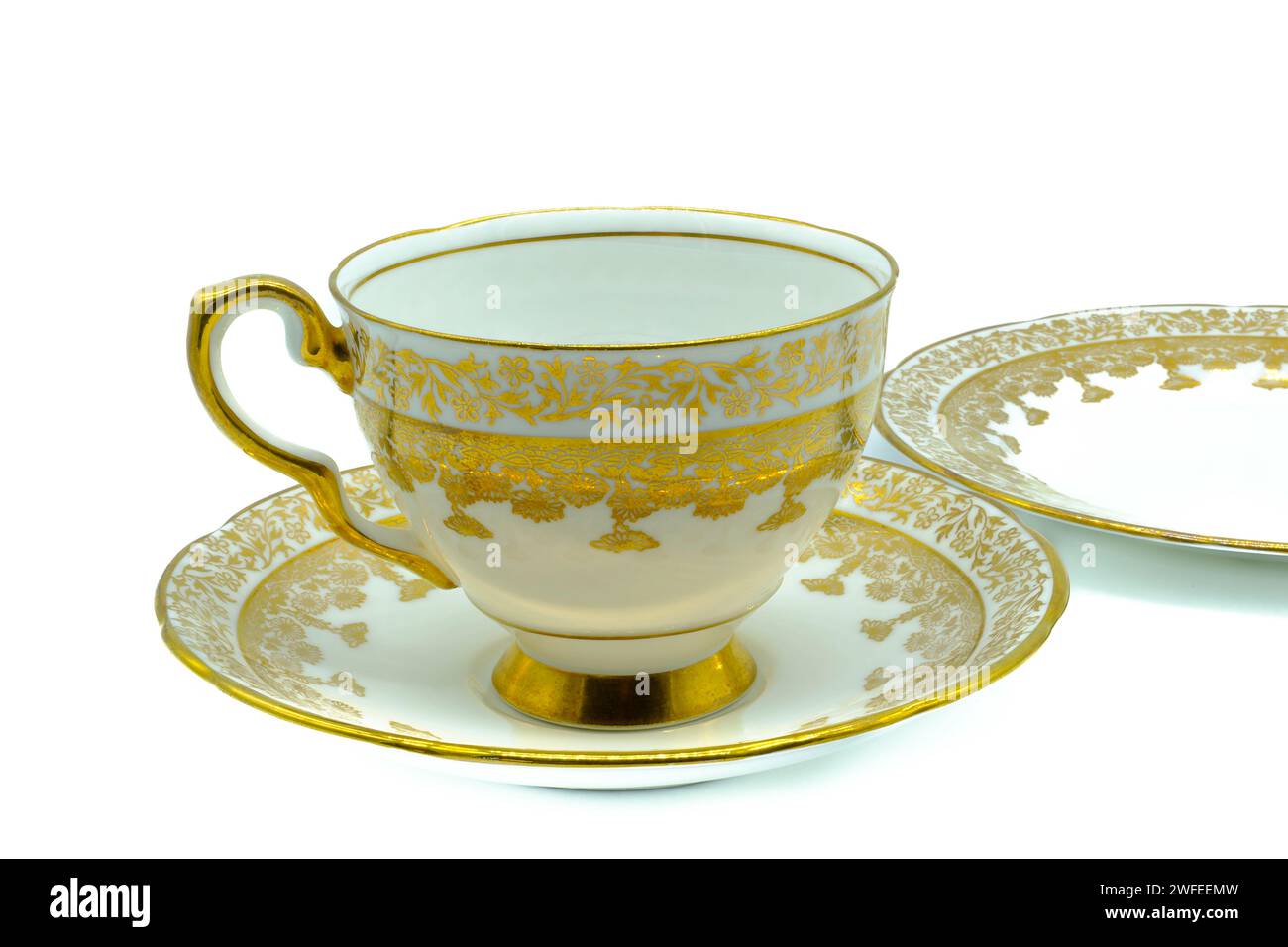 Antiker Tassenuntertasse mit Knochen china und Teeplatte in Gold bemalten Blumen-Design und goldvergoldeten Kanten auf weißem Hintergrund Stockfoto