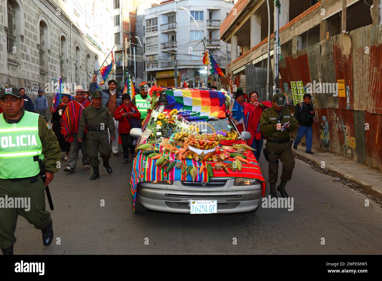 La Paz, BOLIVIEN; 24. Januar 2015. Die bolivianische Polizei eskortiert eine antike illa (oder Statue) eines Ekeko (ein Gott des Überflusses der Aymara), während sie auf einem dekorierten Auto durch die Straßen von La Paz gleitet, um ihren ersten Auftritt beim Alasitas-Festival zu feiern, das heute beginnt. Die Statue ist etwa 2000 Jahre alt und wurde von der Pucara-Kultur hergestellt. Sie wurde 1858 von der archäologischen Stätte Tiwanaku in die Schweiz gebracht und im November 2014 vom Geschichtsmuseum Bern nach Bolivien zurückgegeben. Stockfoto