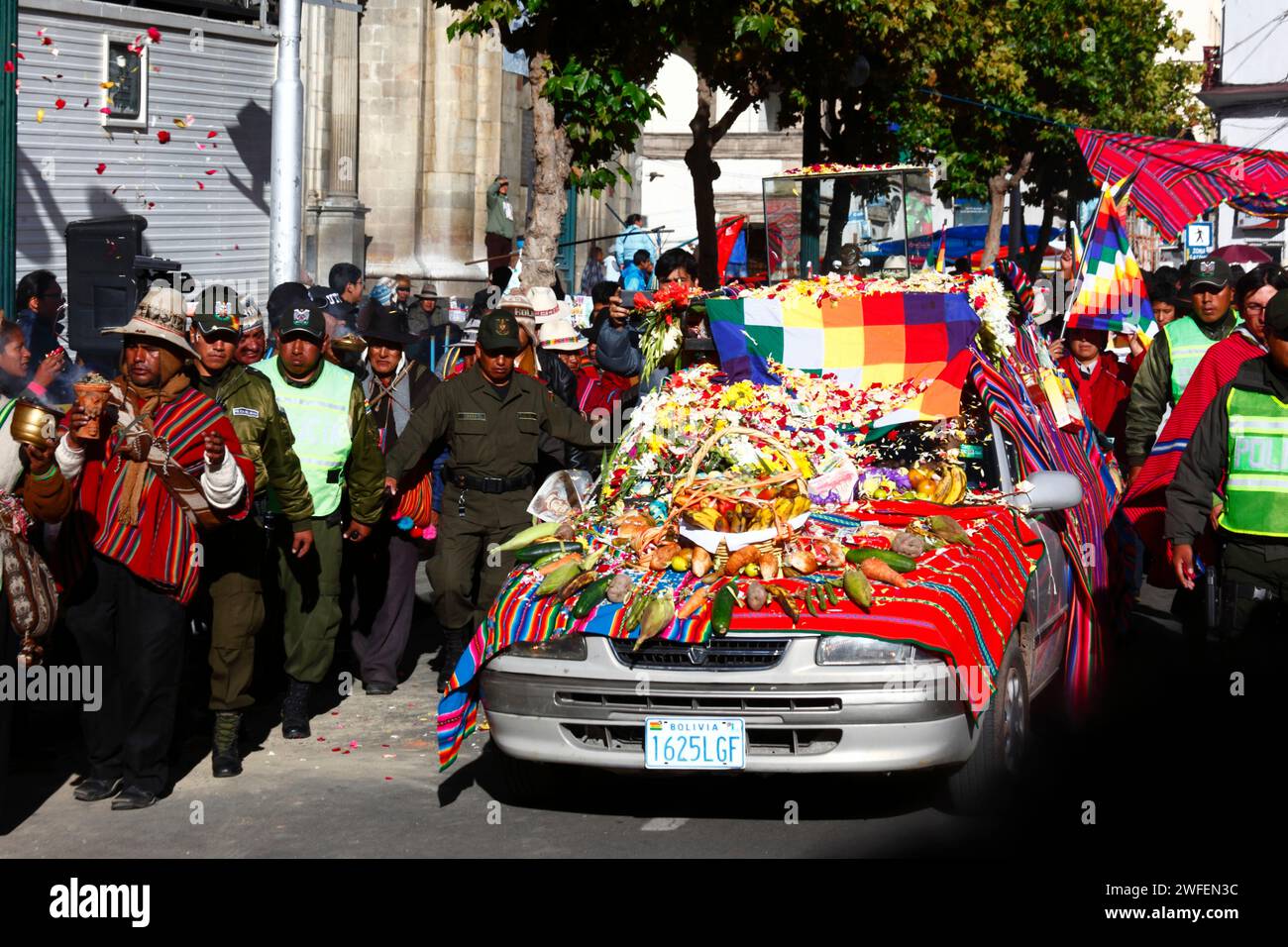 La Paz, BOLIVIEN; 24. Januar 2015. Die bolivianische Polizei eskortiert eine antike illa (oder Statue) eines Ekeko (ein Gott des Überflusses der Aymara), während sie auf einem dekorierten Auto durch die Straßen von La Paz gleitet, um ihren ersten Auftritt beim Alasitas-Festival zu feiern, das heute beginnt. Die Statue ist etwa 2000 Jahre alt und wurde von der Pucara-Kultur hergestellt. Sie wurde 1858 von der archäologischen Stätte Tiwanaku in die Schweiz gebracht und im November 2014 vom Geschichtsmuseum Bern nach Bolivien zurückgegeben. Stockfoto