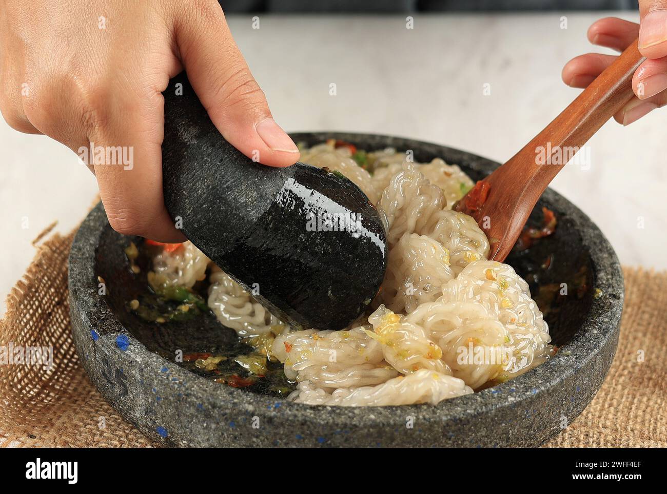 Seblak Cobek Rafael, weiblicher Hand-Mix-Cracker mit Knoblauch-Gewürz Stockfoto