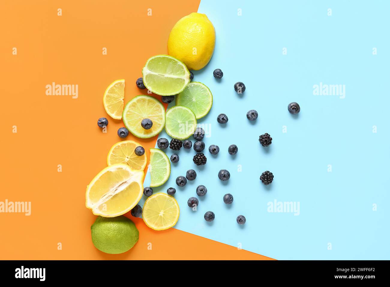 Komposition mit frischen Zitrusfrüchten und Beeren auf farbigem Hintergrund Stockfoto