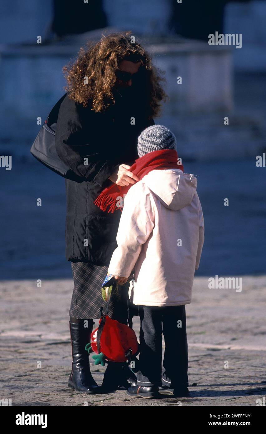 Frau, die sich um Schal auf Kind kümmert, Venedig, Italien Stockfoto