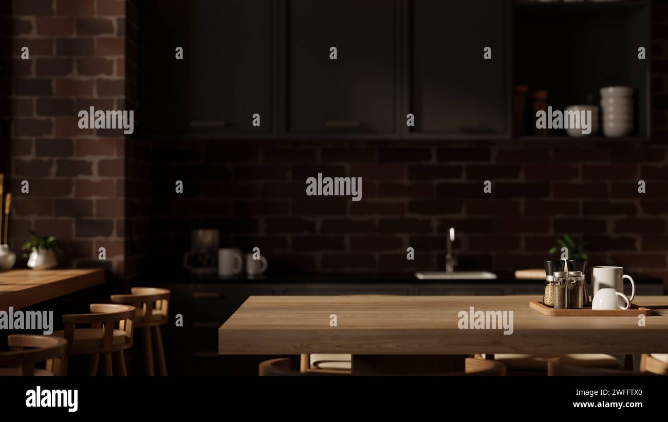 Ein Platz für die Präsentation Ihres Produkts auf einem Esstisch aus Hartholz in einer modernen, dunklen Küche mit schwarzen Küchenablagen und Wandschränken sowie einer Backsteinwaage Stockfoto