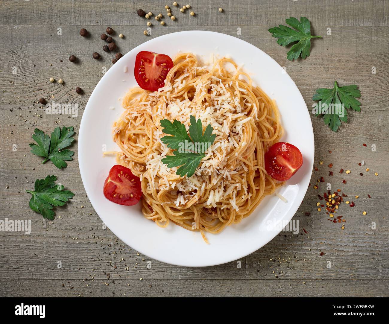 Teller mit Spaghetti mit Bolognesauce und Tomaten auf hölzernem Küchentisch, Blick von oben Stockfoto