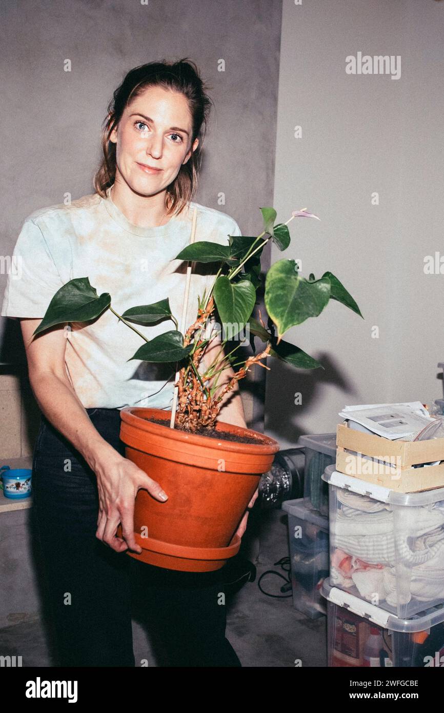 Porträt einer Frau mit Topfpflanzen während der Verlegung des Hauses Stockfoto