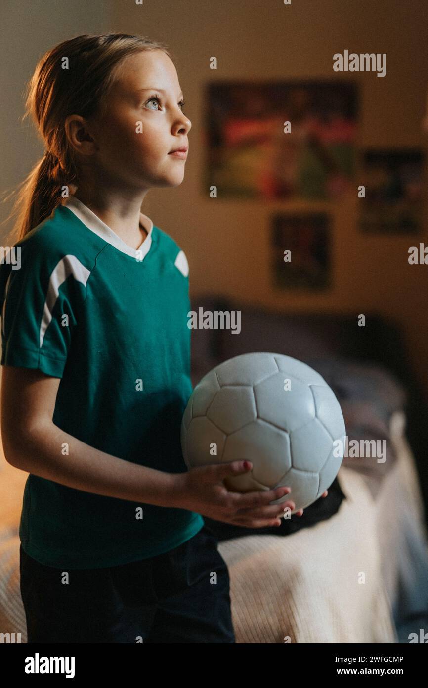 Ein elementares Mädchen mit Fußballtag träumt im Schlafzimmer Stockfoto