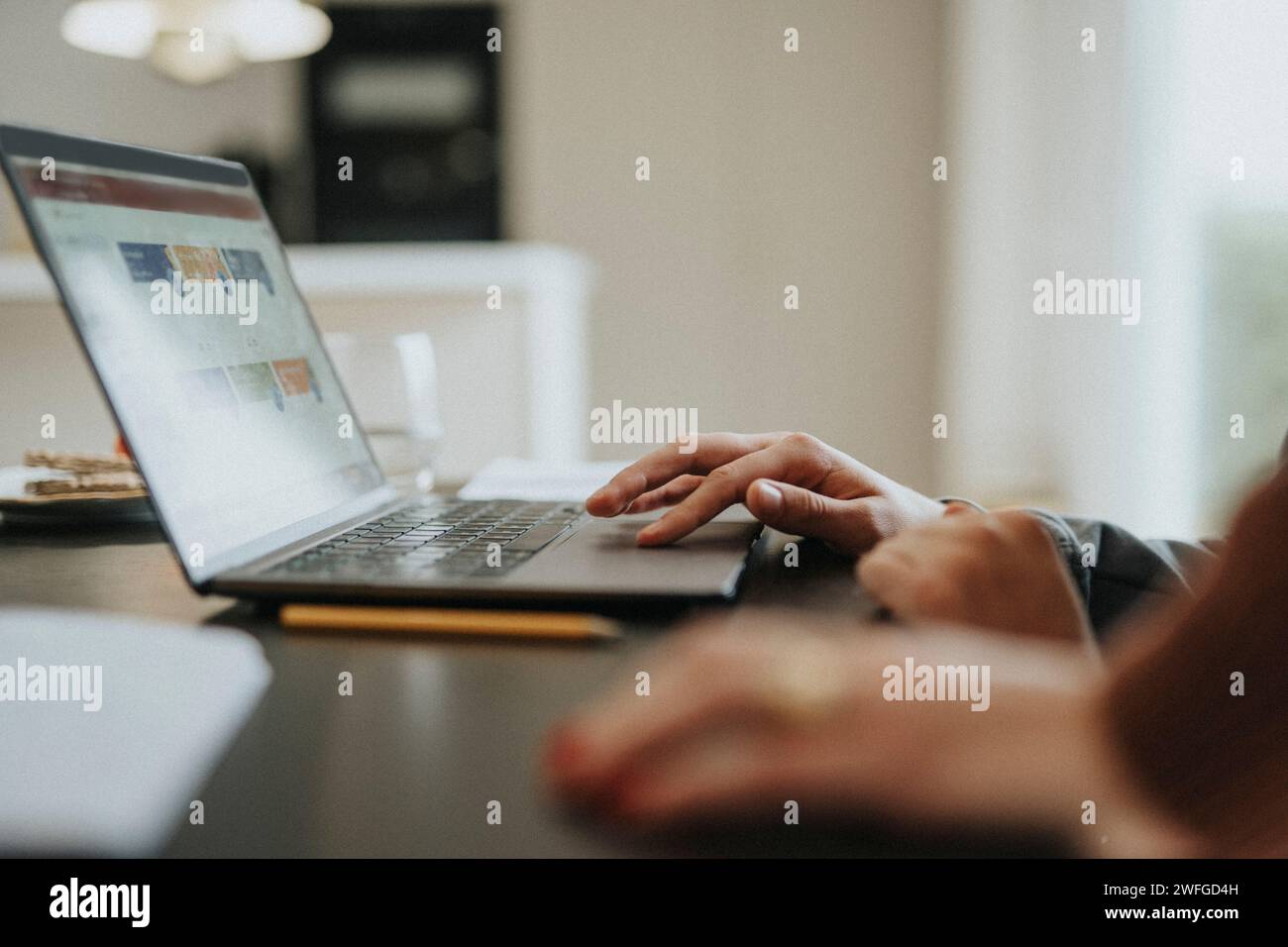 Zugeschnittenes Bild eines Teenagers, der zu Hause ein Notebook verwendet Stockfoto