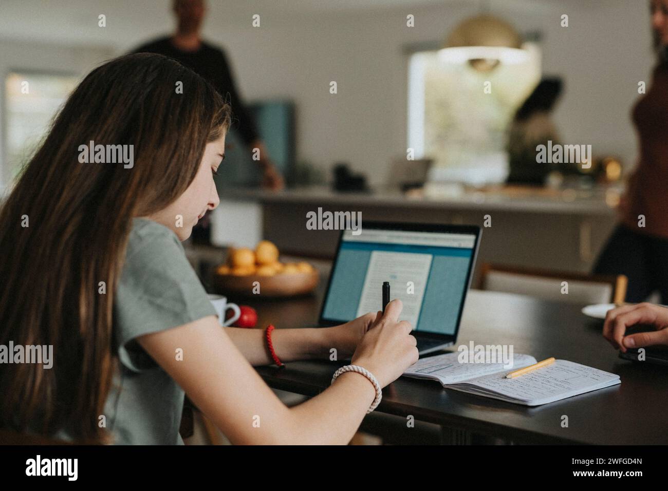 Vorpubertägliches Mädchen, das zu Hause einen Laptop benutzt Stockfoto