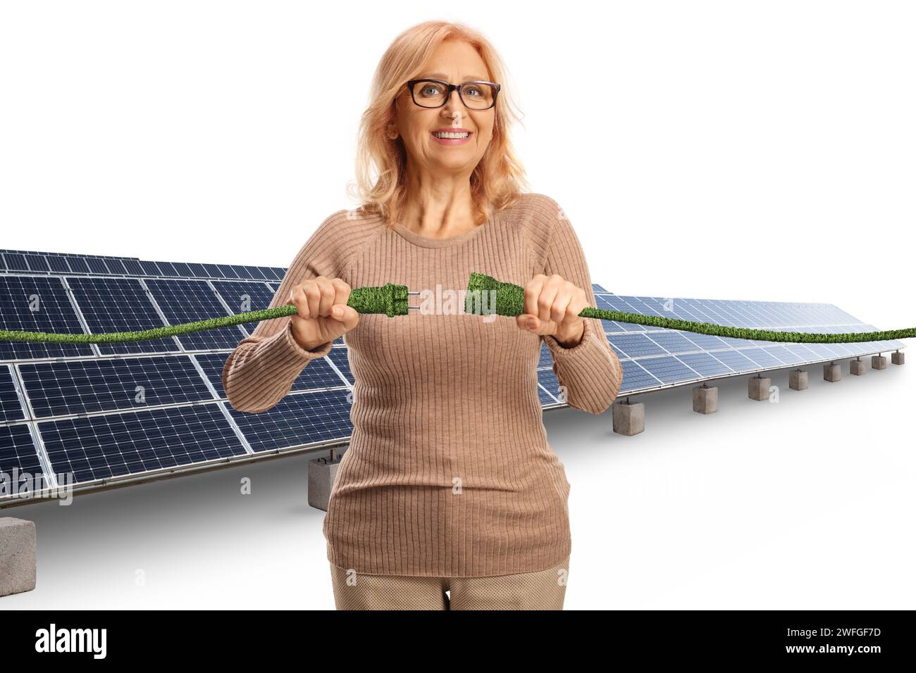 Lächelnde reife Frau auf einem Solarfeld, die grüne elektrische Kabel auf weißem Hintergrund steckte Stockfoto
