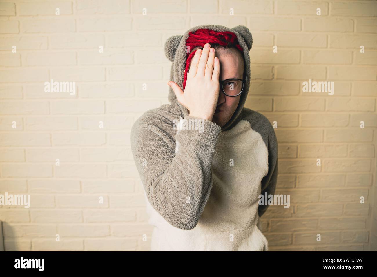 Ein junger, lustiger Hipster mit Brille und roten Dreadlocks. Stockfoto