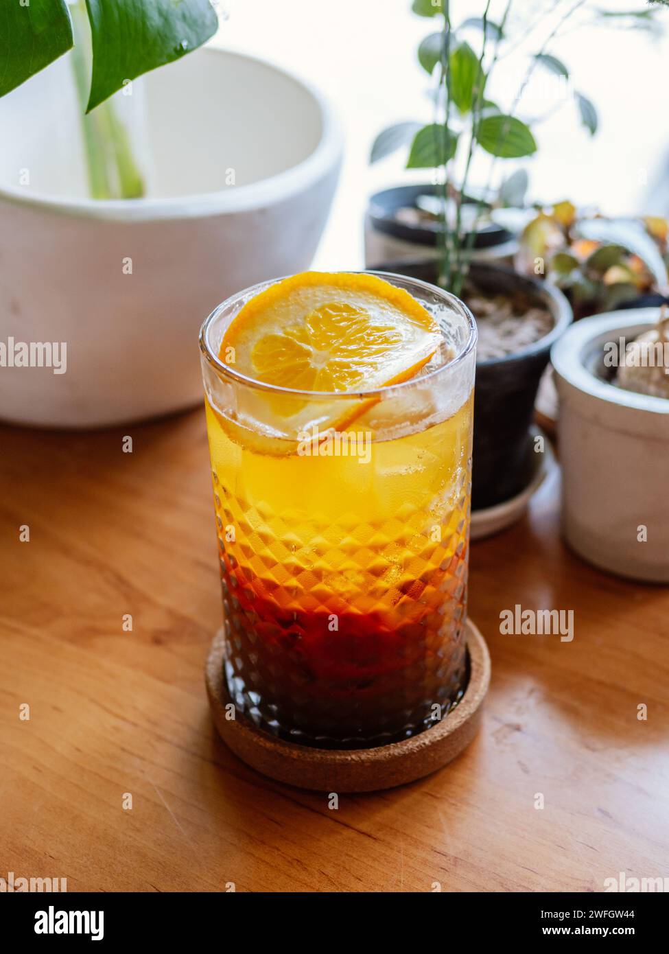 Ein Glas Hummelcocktail mit Eis. Doppelter Espresso mit Orangensaft und Karamellsirup mit Orangensaft und Orangenscheiben auf dem Glas. Frisch und Stockfoto