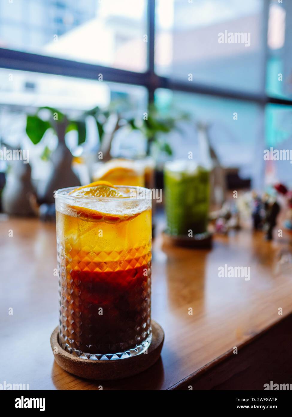 Ein Glas Hummelcocktail mit Eis. Doppelter Espresso mit Orangensaft und Karamellsirup mit Orangensaft und Orangenscheiben auf dem Glas. Frisch und Stockfoto