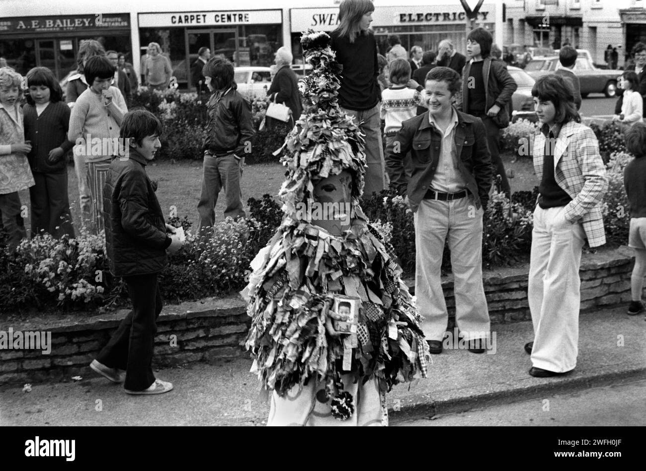 Guiser in Tarnung Boys taling nimmt an einem lovalen jährlichen Folk-Event-Festival Teil. 1970er Jahre Der Junge war gestern Abend als Guisers gekleidet. Guiser mit Sammeldose. 1975 Minehead Somerset West Country England HOMER SYKES Stockfoto