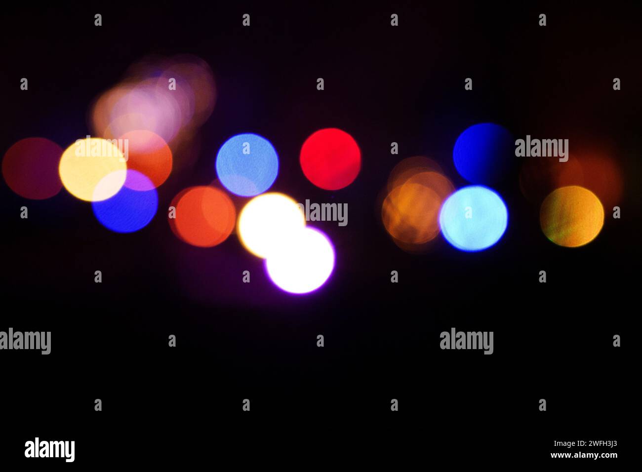 Ein abstrakter Hintergrund mit bunten Lichtern in einem schwach beleuchteten Raum Stockfoto