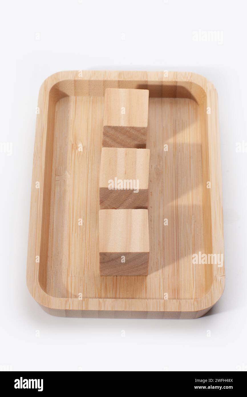 Holztablett mit Würfeln isoliert auf weißer Oberfläche Stockfoto