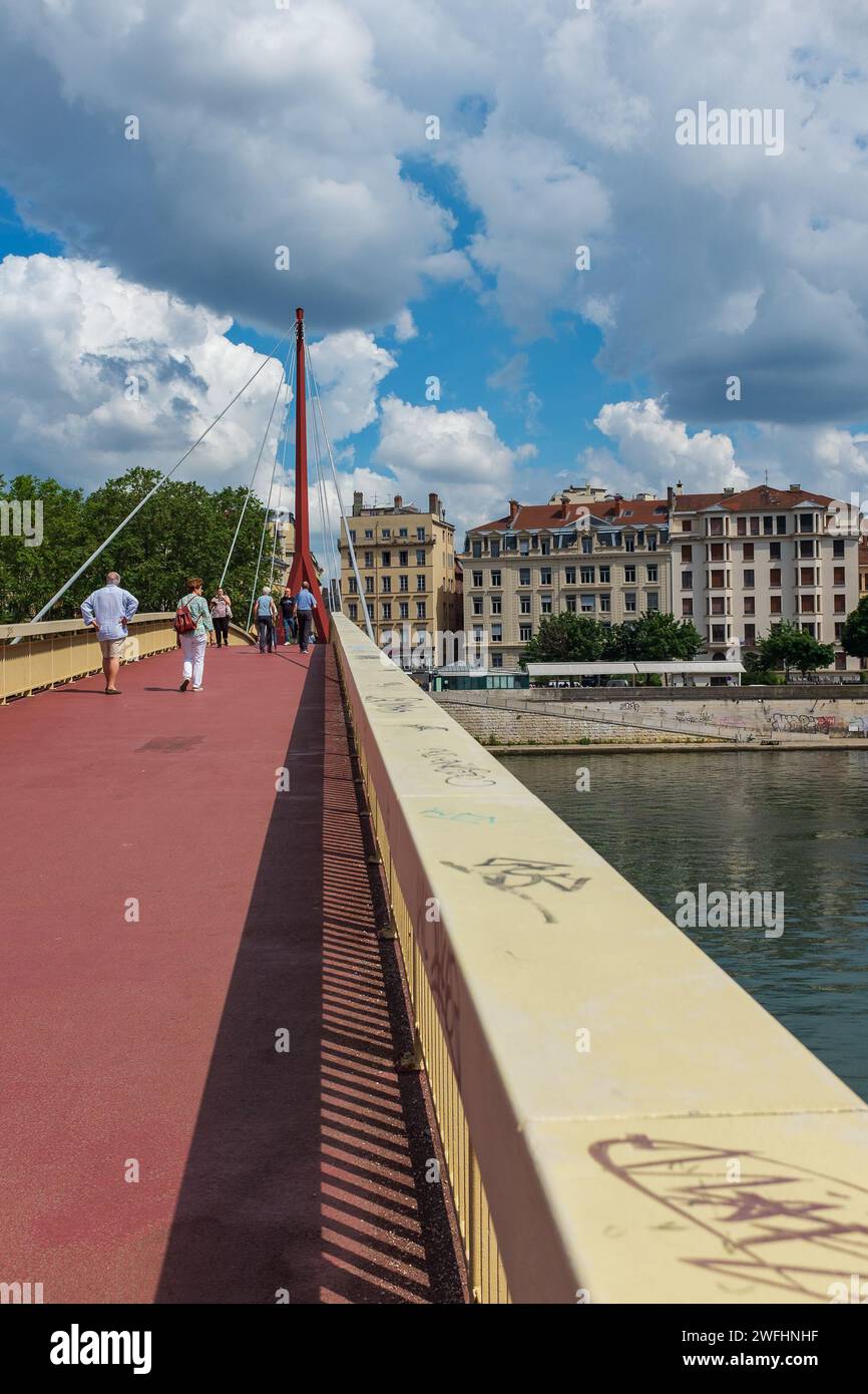 Lyon, Frankreich, 2023. Menschen, die die Brücke Palais de Justice überqueren, mit dem Presqu'île (2. Arrondissement) im Hintergrund (vertikal) Stockfoto