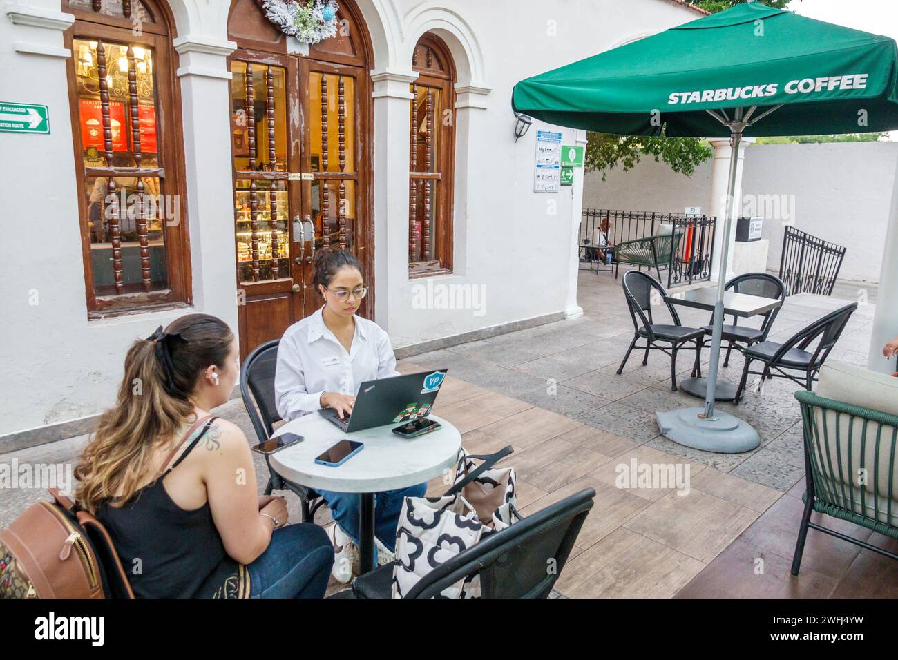 Merida Mexico, Zona Paseo Montejo Centro, Starbucks Café, Tische im Freien, Sonnenschirme, Frauen Frauen Frauen Frauen Frauen Frauen Frauen Frauen, Erwachsene Erwachsene, Residenten, Condu Stockfoto