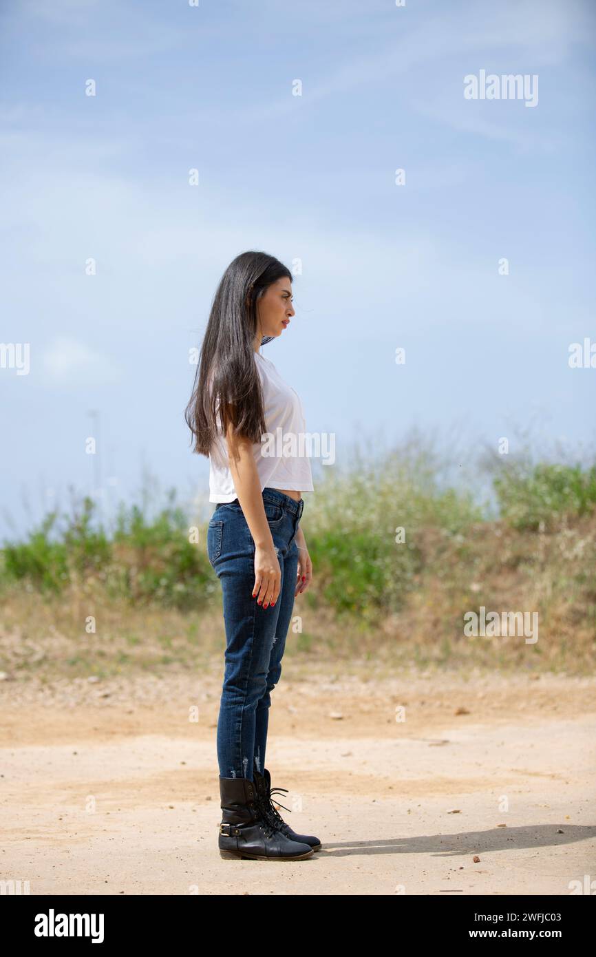 Profilansicht einer einsamen jungen Frau, die draußen steht Stockfoto