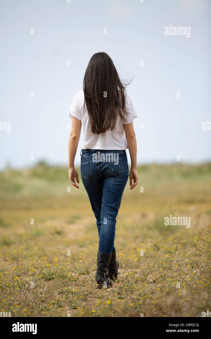 Rückansicht einer schlanken Frau, die draußen weggeht Stockfoto