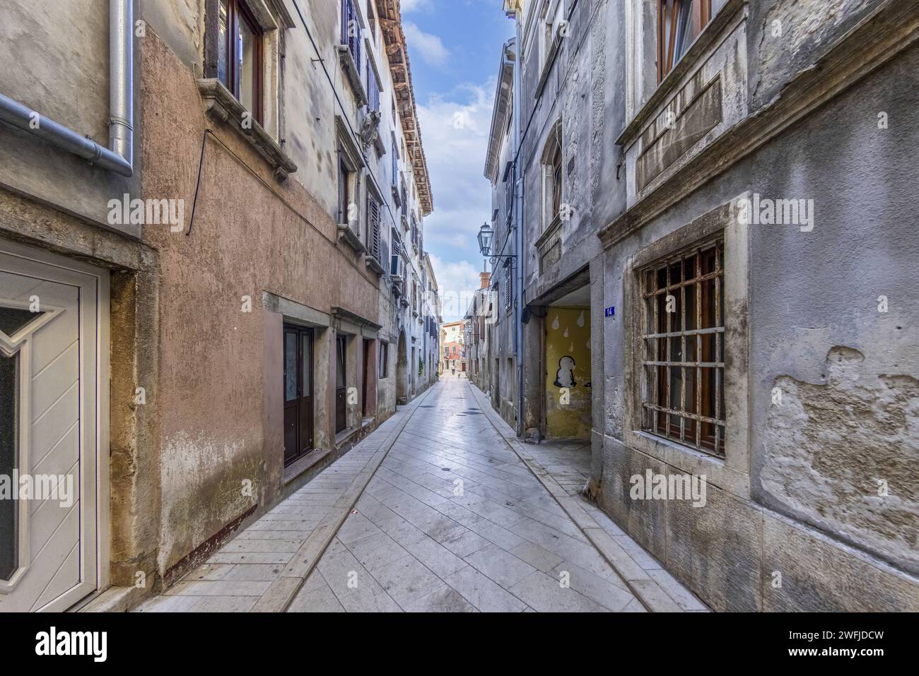 Bild einer typischen Straßenszene aus der historischen kroatischen Stadt Voznjan mit Kopfsteinpflasterstraßen und alten Gebäuden im Morgenlicht Stockfoto