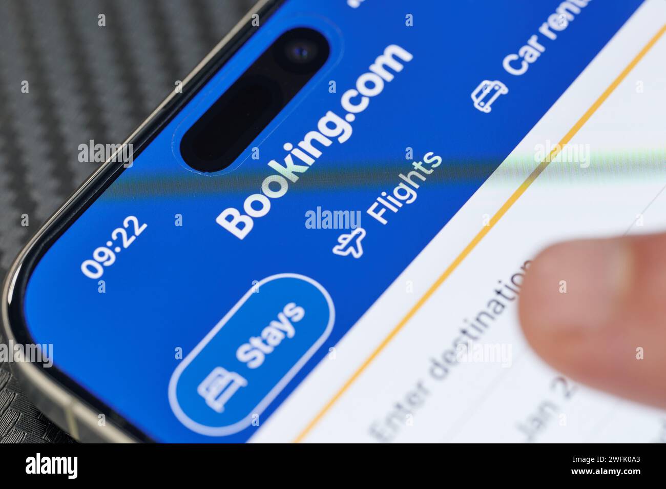 New York, USA – 24. Januar 2024: Suchen Sie ein Hotel in der iphone-App „Buchung“, berühren Sie die Finger aus nächster Nähe Stockfoto