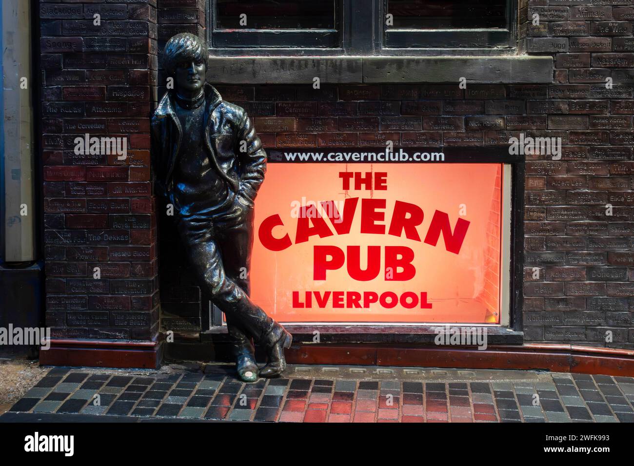 John Lennon Statue gegen die Wall of Fame im Cavern Pub in der Mathew Street in Liverpool Stockfoto