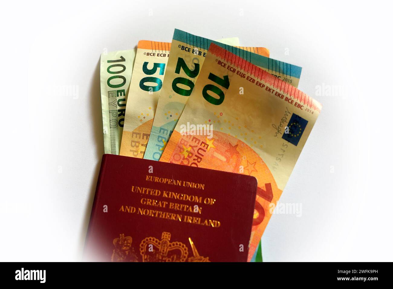 Verschiedene Stückelungen von Euro-Banknoten und ein britischer roter Pass auf der Vorderseite. Studio auf weißem Hintergrund eingerichtet Stockfoto